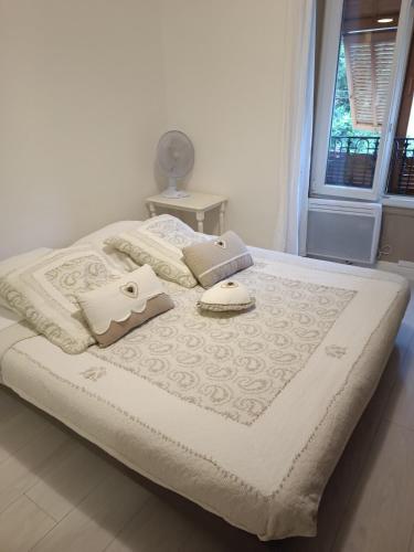 un lit avec des draps et des oreillers blancs et une fenêtre dans l'établissement Night at La Niçoise - 6 per, à Nice