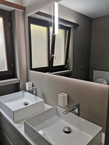 a bathroom with a white sink and a mirror at Mountain View - Trek, Bike, Ski, Lake in Flims