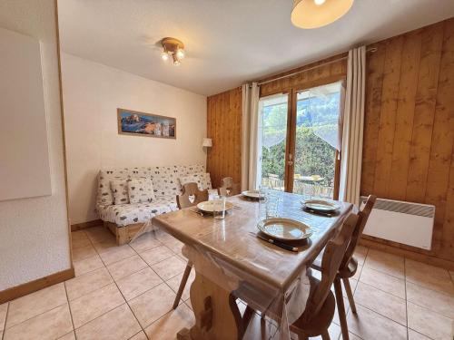 une salle à manger avec une table et un canapé dans l'établissement Charmant Studio Cabine à Praz-Sur-Arly, Ideal Pour 4 avec Parking, Proche Village et Remontées - FR-1-603-17, à Praz-sur-Arly