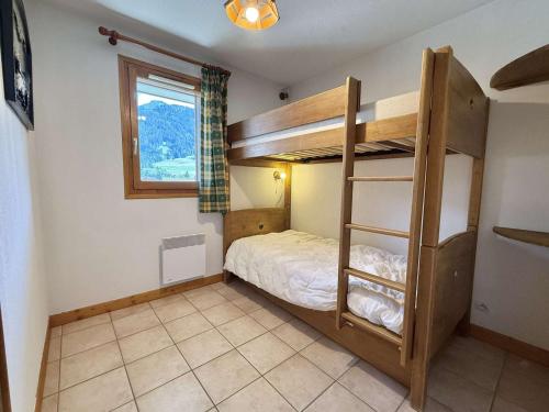 une chambre avec lits superposés et une fenêtre dans l'établissement Spacieux 3 pièces à Praz-sur-Arly, balcon sud-ouest, garage, proche centre et remontées mécaniques - FR-1-603-16, à Praz-sur-Arly