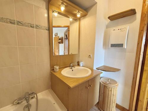 une salle de bain avec un lavabo, une baignoire et un miroir dans l'établissement Spacieux 3 pièces à Praz-sur-Arly, balcon sud-ouest, garage, proche centre et remontées mécaniques - FR-1-603-16, à Praz-sur-Arly