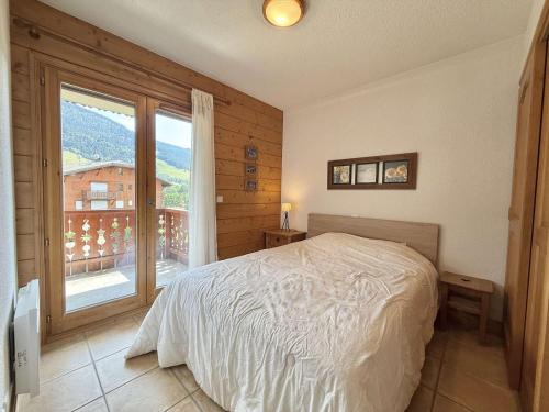 une chambre avec un lit et une grande fenêtre dans l'établissement Appartement cosy à Praz-Sur-Arly - 6 personnes - FR-1-603-124, à Praz-sur-Arly
