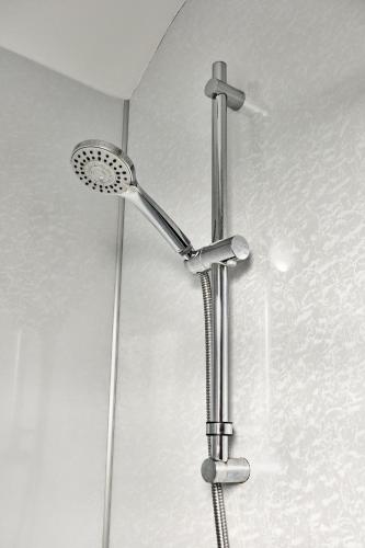 a shower with a shower head in a bathroom at Mc Callstown House Apartment in Ballyclare