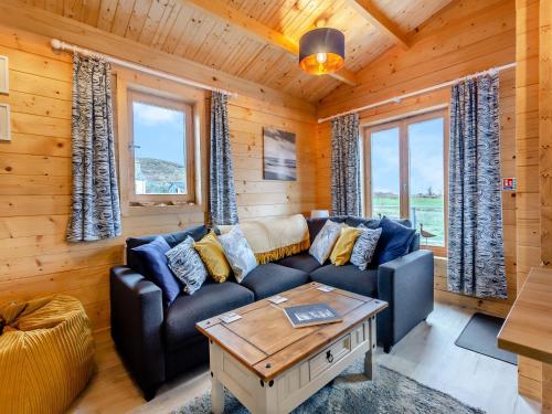 a living room with a couch and a table at Seashell Lodge in Gairloch