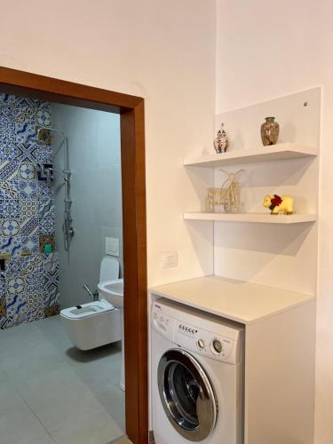 a washing machine in a bathroom with a toilet at Studio Apartment in Sarandë