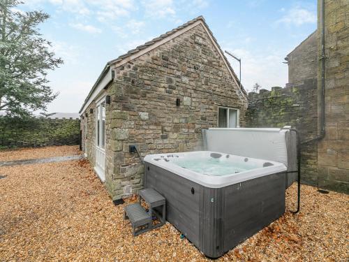 eine Badewanne außerhalb eines Backsteingebäudes in der Unterkunft Syke Farm Cottage in Littleborough