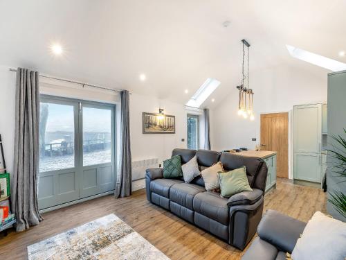 a living room with a couch and a large window at Syke Farm Cottage in Littleborough
