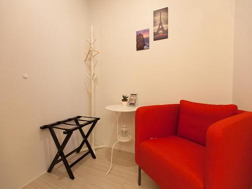a living room with a red couch and a table at 極簡旅行民宿 Simple Travel B&B in Wujie