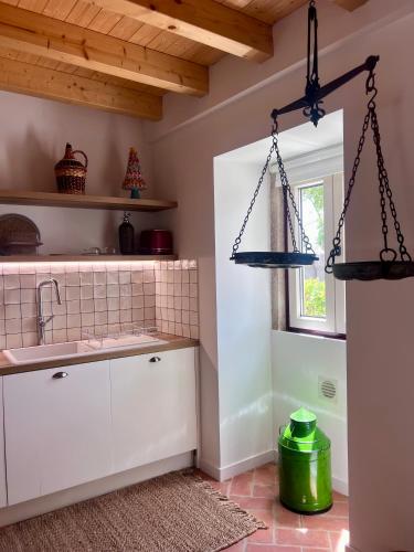 a kitchen with white cabinets and a window at Monte da Aferrada - CASAS DA VILA in Alpalhão