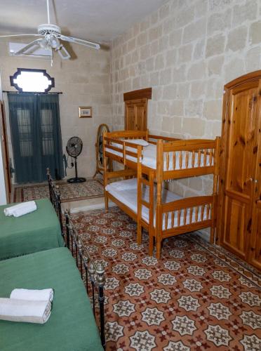 a room with two bunk beds and a ceiling at Tal-Masklu farmhouse in Għarb