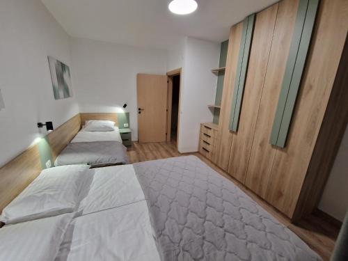 a bedroom with two beds and a window and a door at Avenue Apartments Ilinden in Ilinden