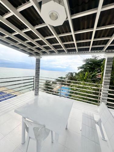 a white dining room with a view of the ocean at Becca's Vacation House 