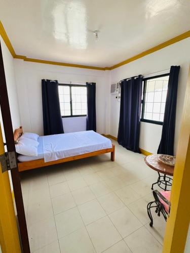 a bedroom with a bed and two windows and a table at Becca's Vacation House 