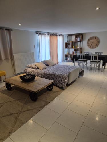 a bedroom with a bed and a table in it at Logement indépendant au rdc d'une maison in Venouse