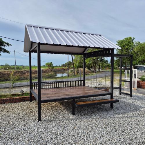 a park bench with a roof on top of it at Lumayan Guesthouse, Pantai Murni in Yan