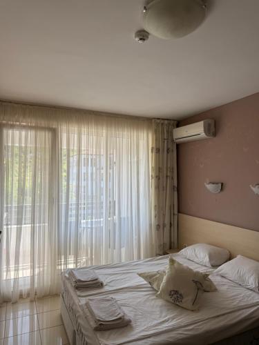 a bed in a room with a large window at Harmony hills view apartments in Rogachevo
