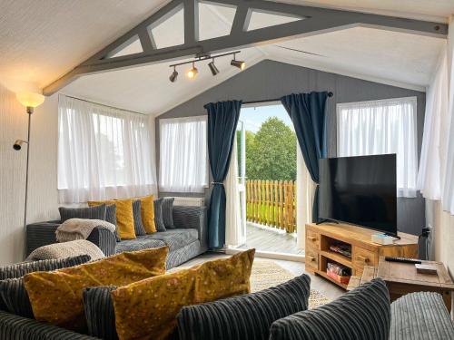 a living room with a couch and a television at Lake View Cottage in Belper