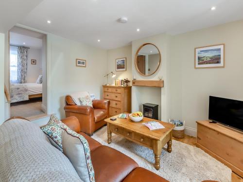 a living room with a couch and a table at Courtyard Cottage in Reeth
