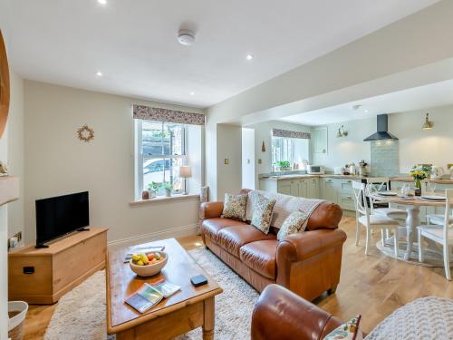 a living room with a couch and a table at Courtyard Cottage in Reeth