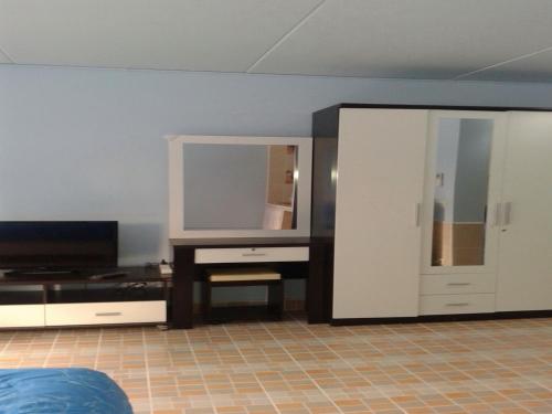 a living room with a tv and a mirror at Smart Residence@Muengthongthani in Nonthaburi