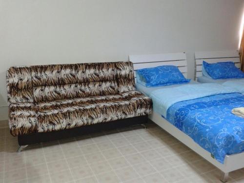 a bedroom with two beds and a couch with a blanket at Smart Residence@Muengthongthani in Nonthaburi