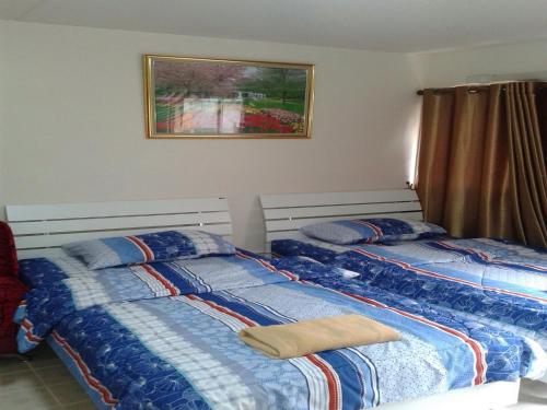 two beds sitting next to each other in a bedroom at Smart Residence@Muengthongthani in Nonthaburi