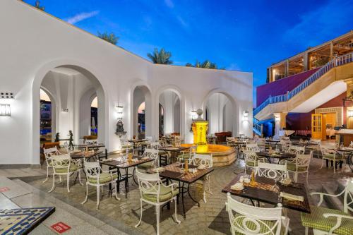 a restaurant with tables and chairs and a building at Savoy Sharm El Sheikh in Sharm El Sheikh