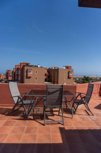 a table and chairs on top of a roof at Banama Coliving & Coworking, Surf & Yoga - Casa Roja in Corralejo