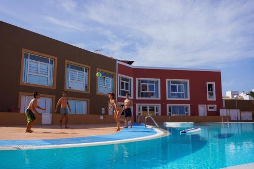 a group of people playing with a frisbee in a swimming pool at Banama Coliving & Coworking, Surf & Yoga - Casa Roja in Corralejo