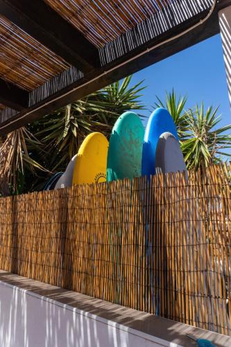 a row of colorful objects on top of a wooden fence at Banama Coliving & Coworking, Surf & Yoga - Casa Roja in Corralejo