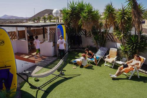 a group of people sitting on the roof of a house at Banama Coliving & Coworking, Surf & Yoga - Casa Roja in Corralejo