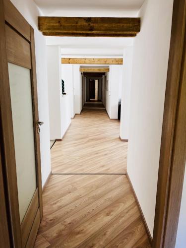 an empty hallway with a wooden floor and a door at The Mountain Sky Apartment - prostorný loft 212 m2 s lesem za okny vhodný pro rodiny s dětmi, terasa, dětský koutek, parkování zdarma in Jeseník
