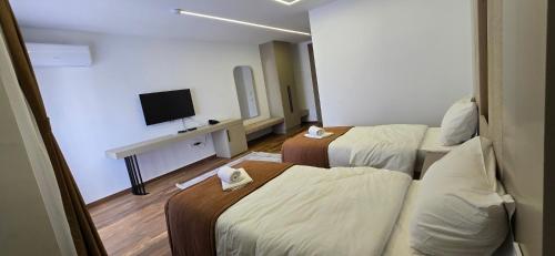 a hotel room with two beds and a flat screen tv at Hotel Pojata in Gjilan