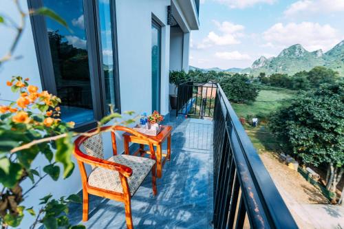 a balcony with two chairs and a table at Green Riverside Cosy Home in Bố Trạch