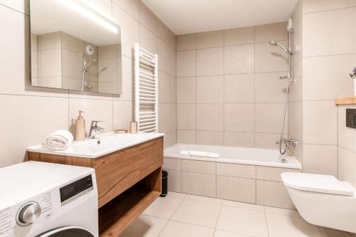 une salle de bain blanche avec une machine à laver à l'intérieur dans l'établissement Appartement moderne - Les houches, aux Houches