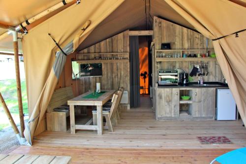 a tent with a table and a kitchen in it at Safarizelte in Lychen