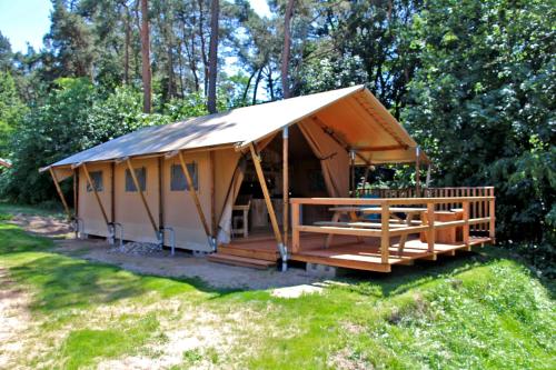 a large tent with a porch in the grass at Safarizelte in Lychen