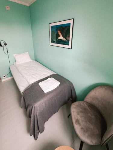 a small bedroom with a bed and a chair at Finnholmen Brygge in Henningsvær