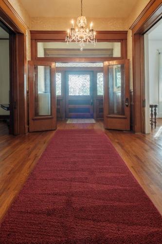 a large room with a red carpet and a chandelier at Oakridge House. Spacious and historic home in downtown Ironton, Ohio. in Ironton