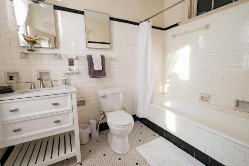 a bathroom with a toilet and a sink and a tub at Oakridge House. Spacious and historic home in downtown Ironton, Ohio. in Ironton