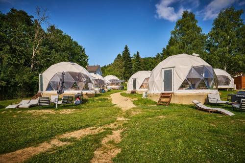 a row of tents in a field of grass at Glamping Slapy in Slapy