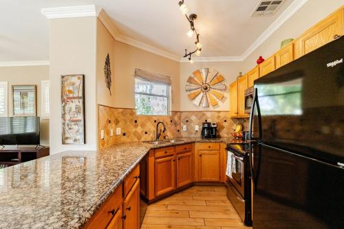 a kitchen with wooden cabinets and a black refrigerator at Amazing Gilbert home 3 Bed 2 and half Bath sleeps 8 2 car garage in Gilbert