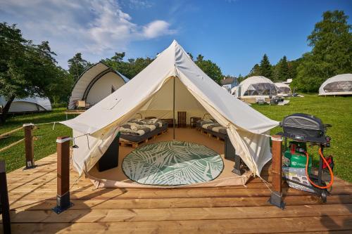 a white tent with a bed in it on a deck at Glamping Slapy in Slapy