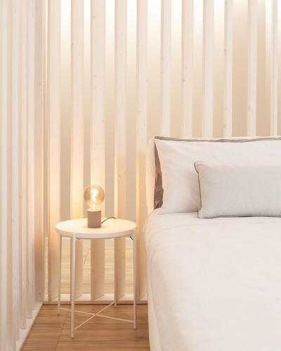 a bed with a side table with a candle on it at Rimini Centro Loft Open Space Titan's Lair in Rimini