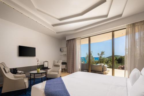 a hotel room with a bed and a view of the ocean at Villa Nai 3.3 in Žman