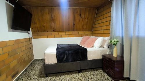 a bedroom with a bed and a television in a room at Alojamiento casa campestre Barbosa Santander in Barbosa
