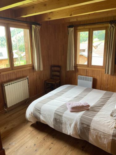 une chambre avec un lit avec deux serviettes dessus dans l'établissement All-wood chalet in Haute-Savoie, à Nancy-sur-Cluses