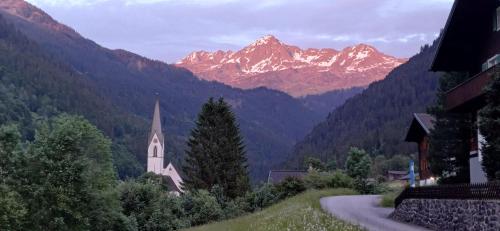 a church and a road with mountains in the background at Alpenliebe Montafon in Silbertal