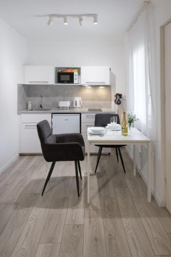 a kitchen with a table and a chair in a room at Nefelejcs Vendégház in Gödöllő