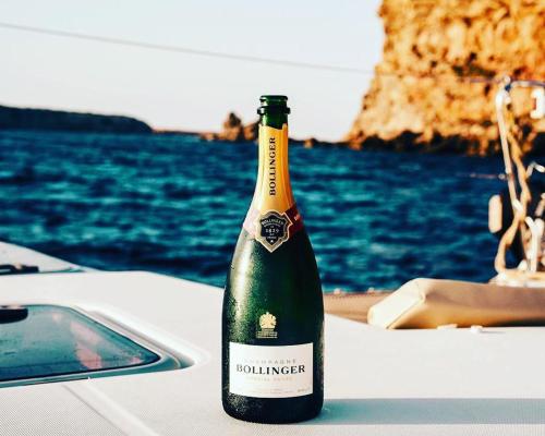 una botella de vino encima de un barco en White Suites Ibiza, en Playa d'en Bossa